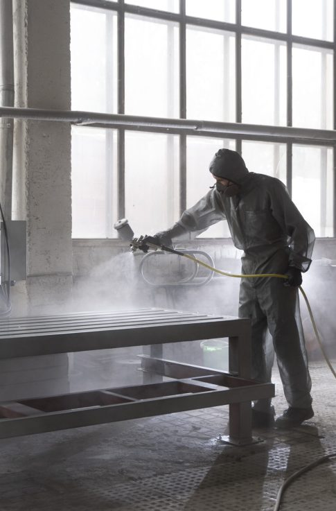 man-spraying-powder-paint-from-gun-full-shot